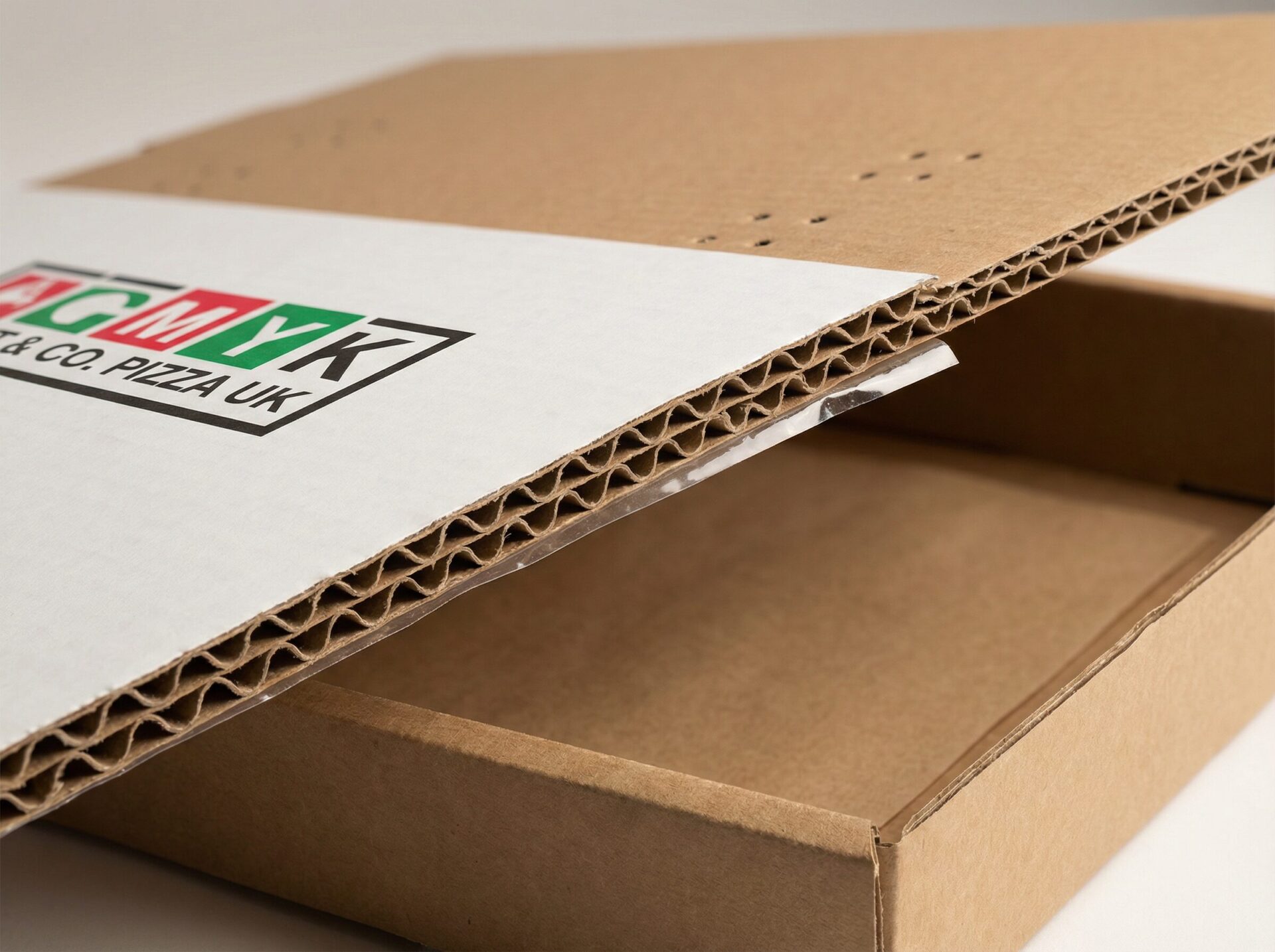Custom pizza box UK close-up showing E-flute corrugated board, steam vents and CMYK print - Wabs Print